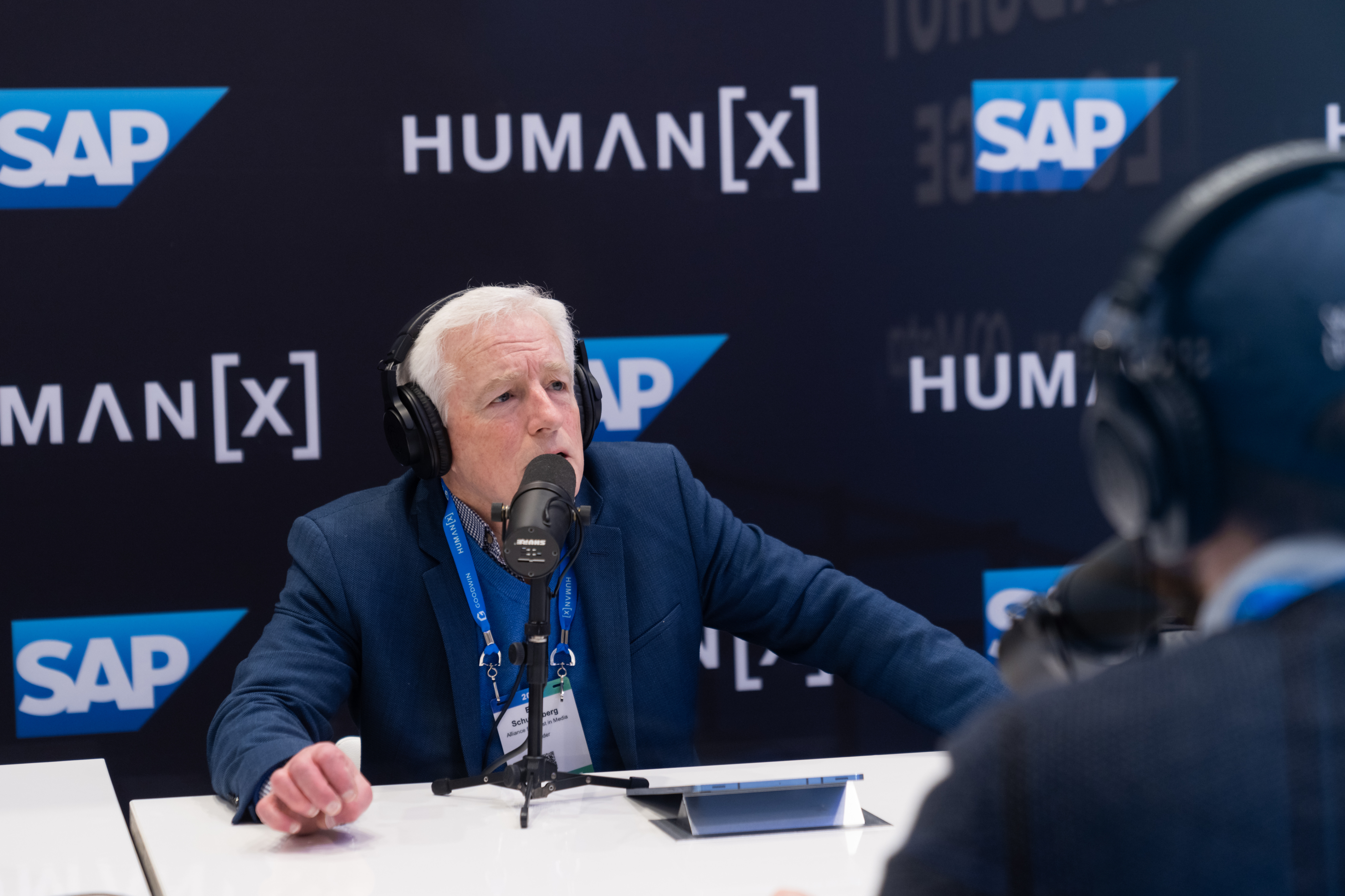 A man is mid sentence while being interviewed at the podcasth booth at humanx 2025